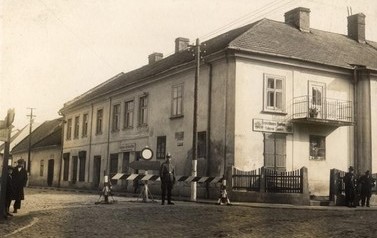 Zdjęcie przedstawia wjazd w ulicę Krakowską od strony Rynku. Widać na nim budynek, kt&oacute;ry dziś  nazywa się &bdquo;Kościuszki 1&rdquo;, a kiedyś m&oacute;wiło się o nim &ndash; &bdquo;Kamienica Piechowiczowska&rdquo;. Dawno temu mieścił się w nim dom zajezdny z obszernym podw&oacute;rzem, wozownią i 