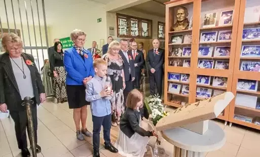 tłum ludzi oddaje hołd przed pamiątkową tablicą