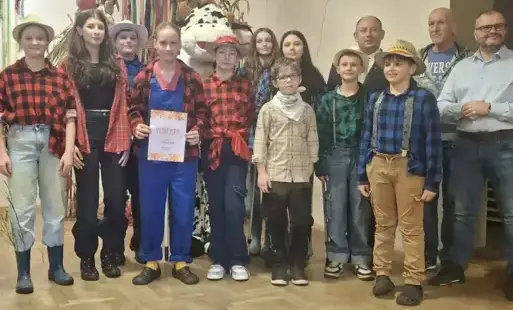 grupa osób w farmerskich strojach pozuje do zdjęcia
