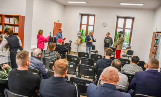 burmistrz stoi na tle zdjęcia, rozmawia z organizatorami radio road story podczas uroczystego otwarcia gazety