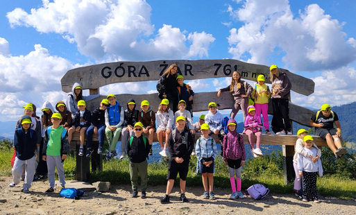 dzieci stoją na kamienistej drodze pod znakiem góra żar i pozują do zdjęcia