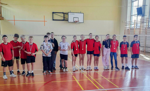 uczniowie - uczestnicy turnieju w badmintonie - stoją na tle sali gimnastycznej 