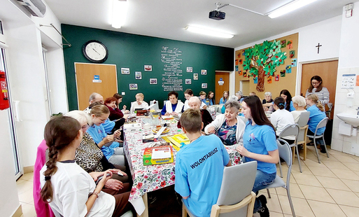 uczniowie - wolontariusze siedzą wraz z seniorami w domu senior-wigor i grają w planszówki
