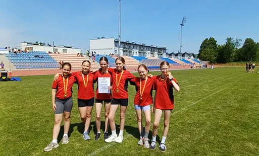 reprezentantki sp nr 2 w kętach stoją i pozują do zdjęcia na tle stadionu w tarnowie
