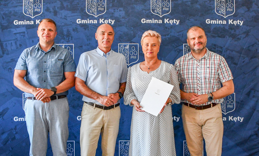 na tle banera gminy kęty pozują kolejno od lewej II zastępca Burmistrza Marcin Blok, I zastępca burmistrza Rafał Ficoń, nowo mianowana dyrektorka ZSP nr 3 w Kętach Dorota Żaczek, burmistrz gminy Kęty Marcin Śliwa