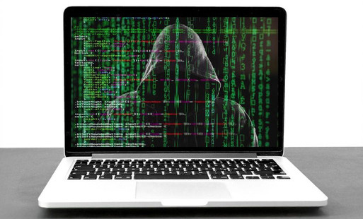 Zakapturzona osoba na ekranie laptopa